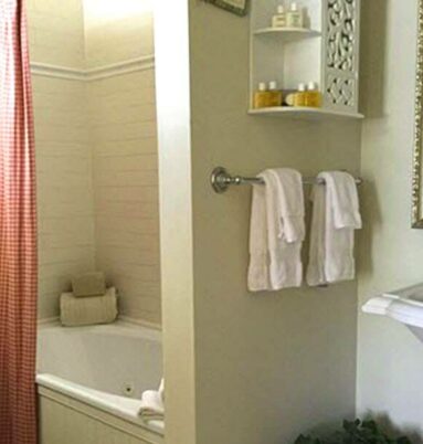 bathroom with red shower curtain, white towels, pedestal sink