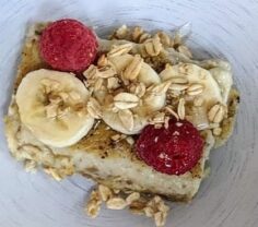breakfast topped with bananas and raspberries