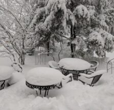 tables and chairs covered by snow
