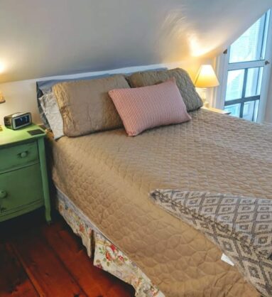 bed with brown bedspread next to green night table